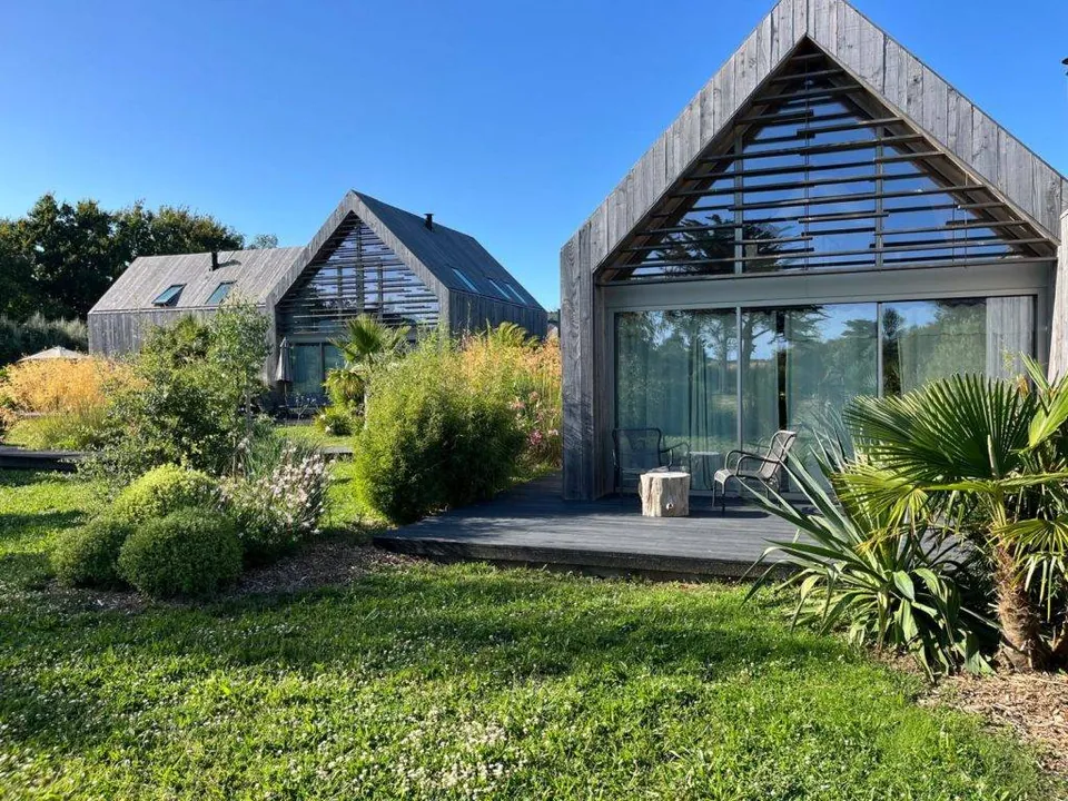 La terrasse en bois et la façade vitrée d’un lodge Suite